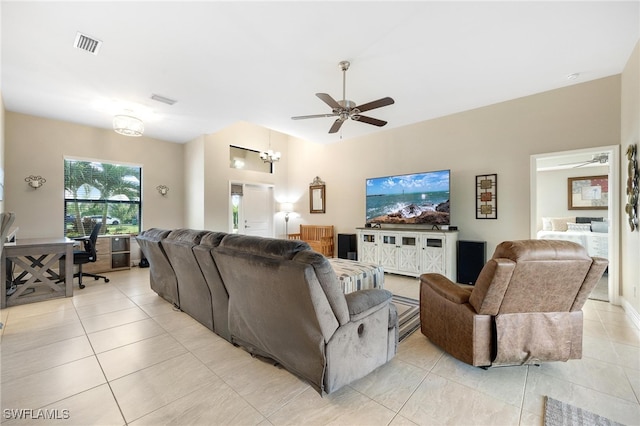 living room featuring ceiling fan with notable chandelier and light tile patterned floors