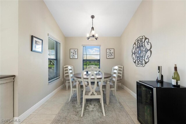 tiled dining space with lofted ceiling and a notable chandelier