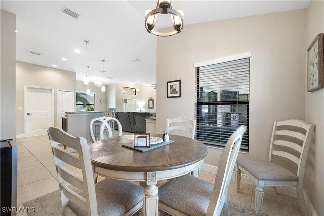 tiled dining space featuring an inviting chandelier