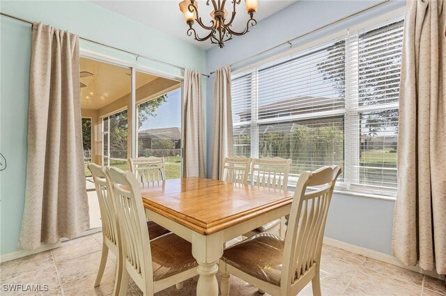 tiled dining room featuring a notable chandelier