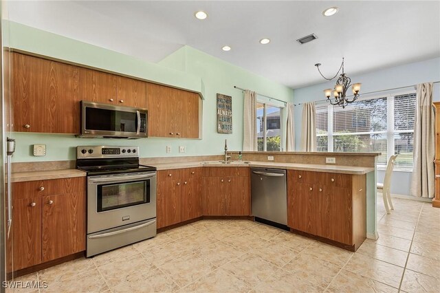 kitchen with light tile patterned flooring, stainless steel appliances, sink, and a wealth of natural light