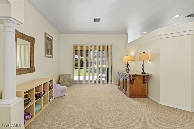 interior space featuring light carpet and ornate columns