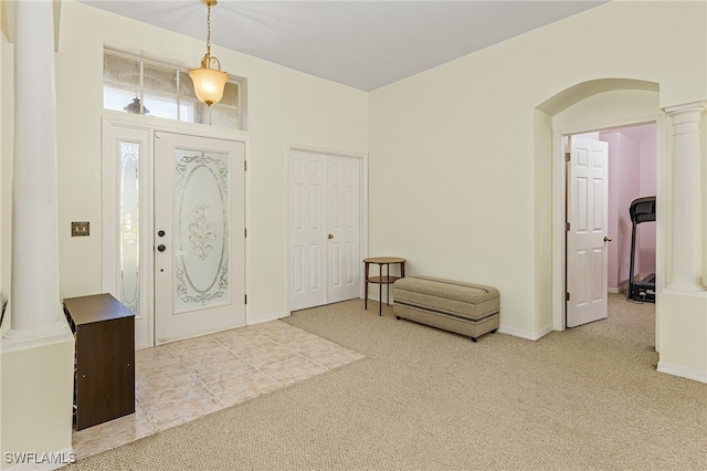 carpeted entrance foyer with decorative columns