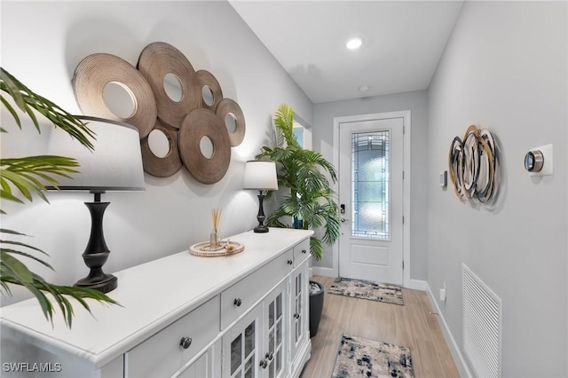 entryway with baseboards, visible vents, and light wood-style floors