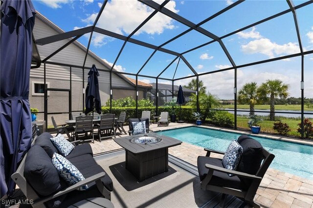 view of pool featuring an outdoor living space with a fire pit, a patio, a water view, and glass enclosure