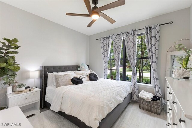 bedroom featuring multiple windows, ceiling fan, and light hardwood / wood-style flooring