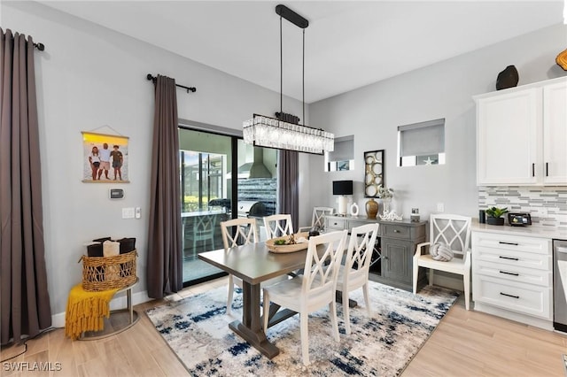 dining space featuring light wood-style flooring and baseboards