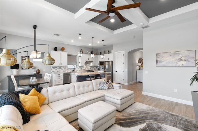 2740 Amaranda Ct, Naples, FL 34114 - living area with coffered ceiling, a ceiling fan, light wood finished floors, baseboards, and arched walkways