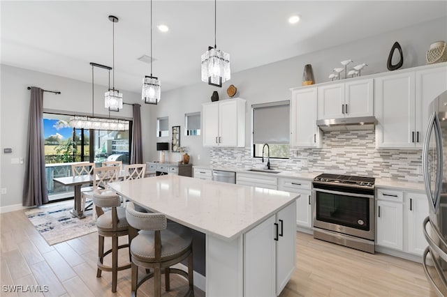 2740 Amaranda Ct, Naples, FL 34114 - kitchen with a sink, a kitchen island, tasteful backsplash, under cabinet range hood, and stainless steel appliances