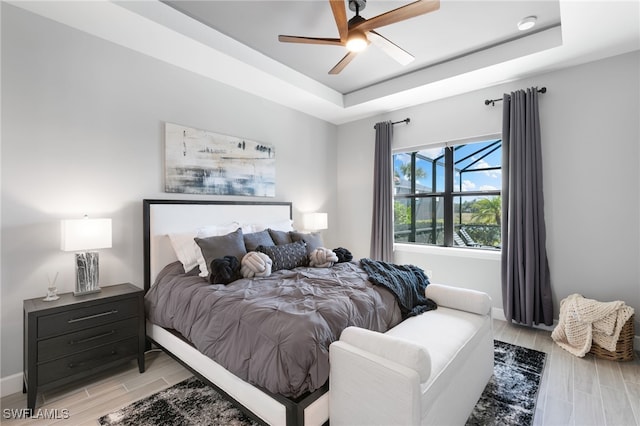 2740 Amaranda Ct, Naples, FL 34114 - bedroom featuring baseboards, wood tiled floor, a ceiling fan, and a raised ceiling