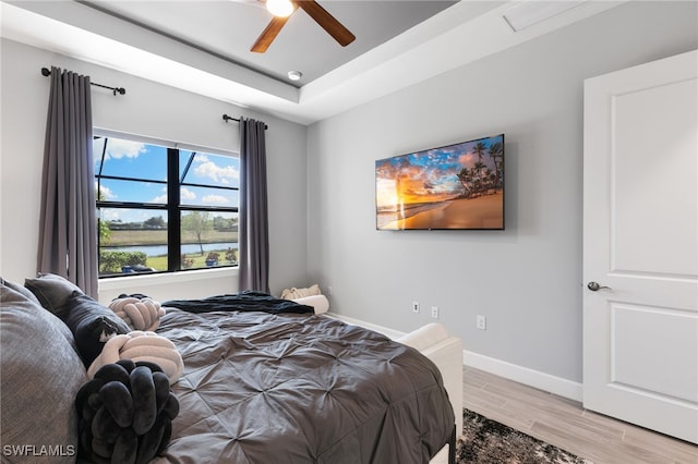 2740 Amaranda Ct, Naples, FL 34114 - bedroom with baseboards, a tray ceiling, a ceiling fan, and light wood finished floors