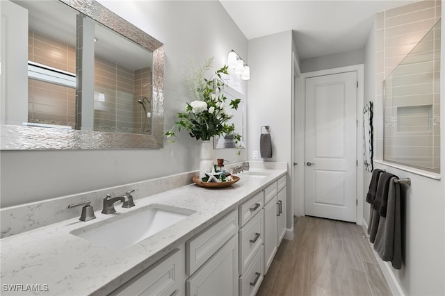 2740 Amaranda Ct, Naples, FL 34114 - bathroom featuring double vanity, a sink, tiled shower, and wood finished floors