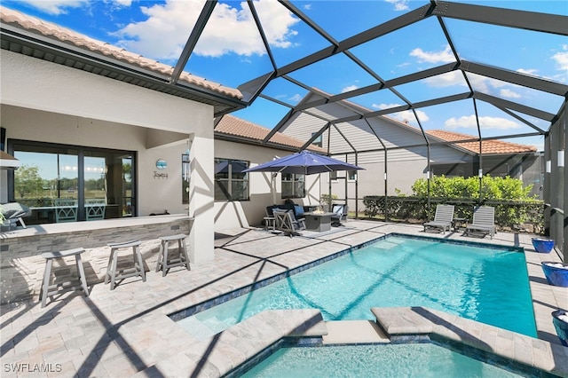 2740 Amaranda Ct, Naples, FL 34114 - view of swimming pool with glass enclosure, a pool with connected hot tub, outdoor dry bar, and a patio