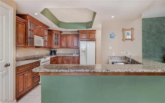 kitchen with light stone counters, light tile patterned floors, sink, kitchen peninsula, and white appliances