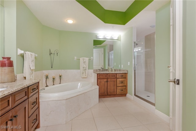 bathroom with tile patterned flooring, shower with separate bathtub, and vanity