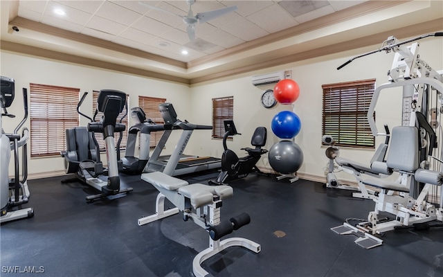 workout area with ornamental molding, a drop ceiling, a tray ceiling, ceiling fan, and a wall mounted AC