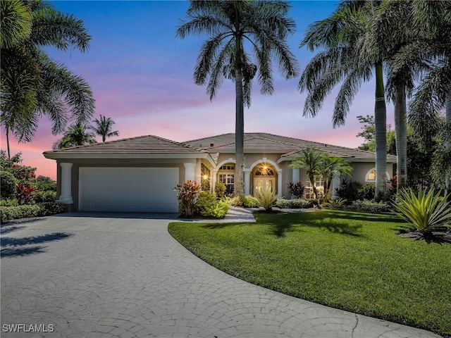 view of front of property with a lawn and a garage