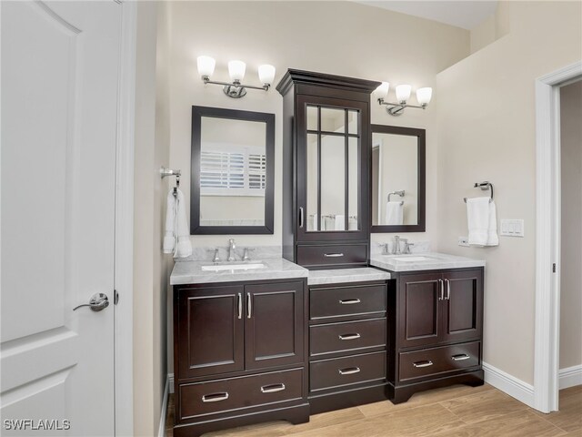 bathroom featuring dual vanity and hardwood / wood-style flooring