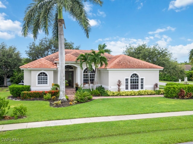 mediterranean / spanish home with a front yard