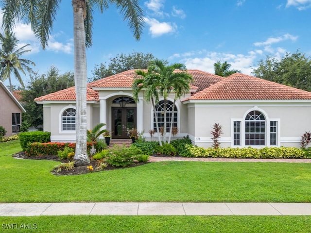 mediterranean / spanish house with french doors and a front lawn