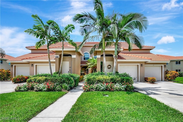 mediterranean / spanish house featuring a front lawn and a garage