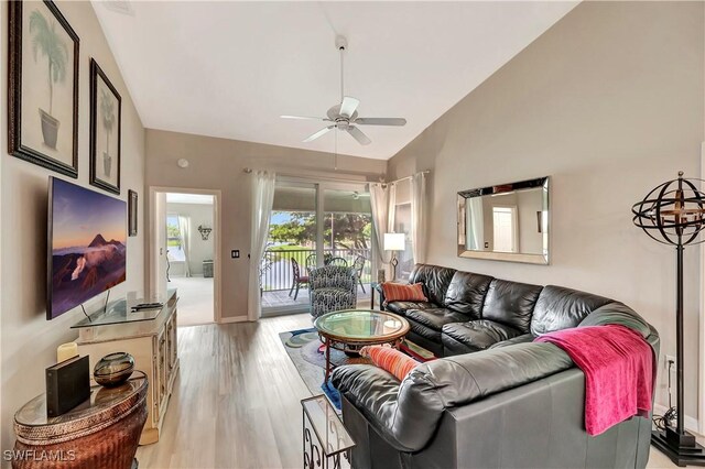 living room featuring ceiling fan, high vaulted ceiling, and light wood-type flooring