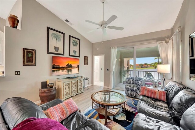 living room featuring ceiling fan, light wood-type flooring, and lofted ceiling