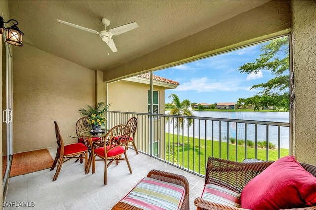 sunroom featuring ceiling fan and a water view