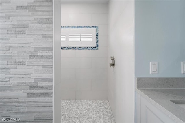 bathroom with vanity and tiled shower