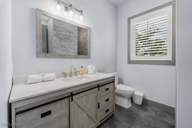 bathroom with tile patterned flooring, vanity, and toilet