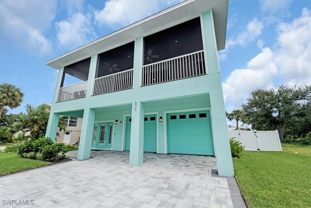 view of front facade featuring ceiling fan, french doors, a front lawn, and a garage