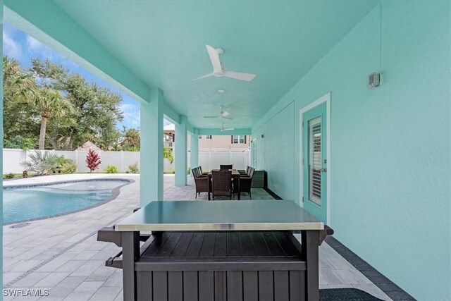 view of swimming pool featuring ceiling fan and a patio area