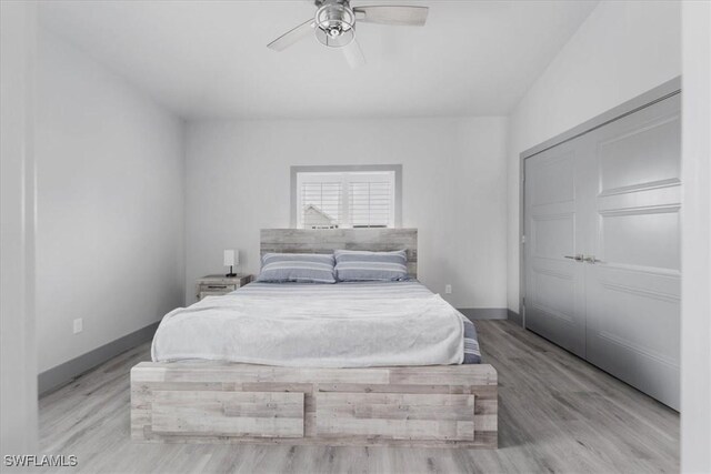 bedroom featuring a closet, light hardwood / wood-style flooring, and ceiling fan