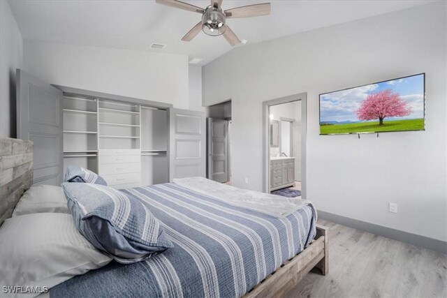 bedroom with ensuite bath, ceiling fan, vaulted ceiling, a closet, and light wood-type flooring