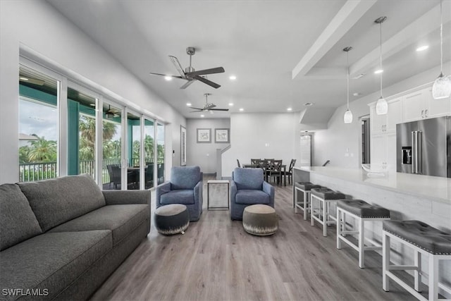 living room with ceiling fan and light wood-type flooring