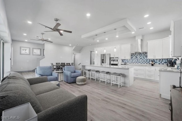 living room featuring ceiling fan and light hardwood / wood-style floors