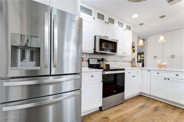 kitchen featuring stainless steel appliances, white cabinets, and light wood-type flooring