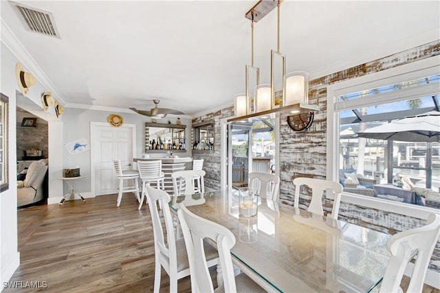 dining space featuring hardwood / wood-style flooring, ornamental molding, and ceiling fan