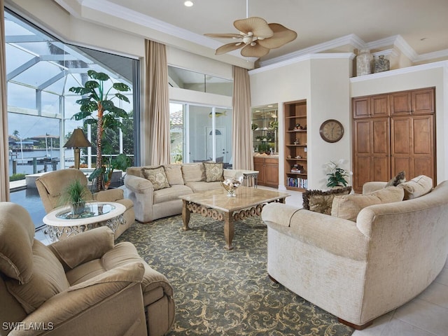 living area featuring a healthy amount of sunlight, a sunroom, ceiling fan, and crown molding