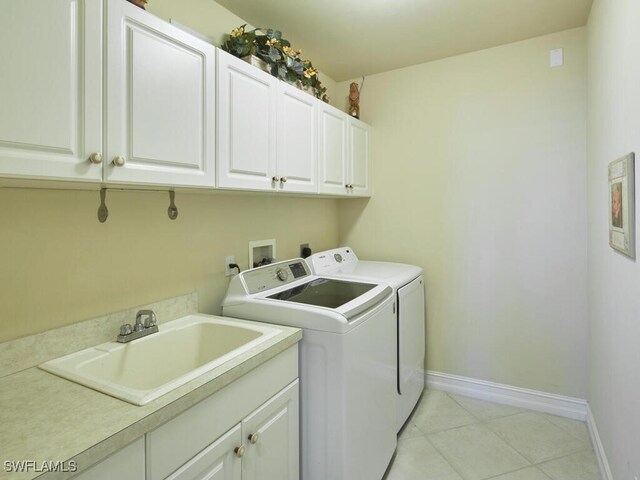 laundry room featuring light tile patterned floors, cabinets, sink, and washer and clothes dryer