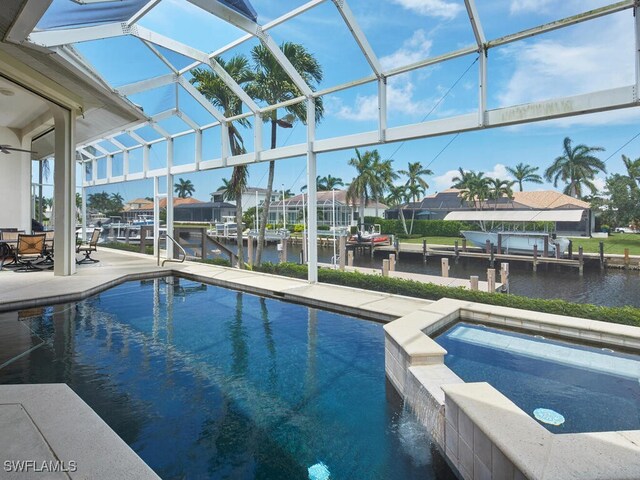 view of swimming pool featuring glass enclosure, a water view, an in ground hot tub, and a dock