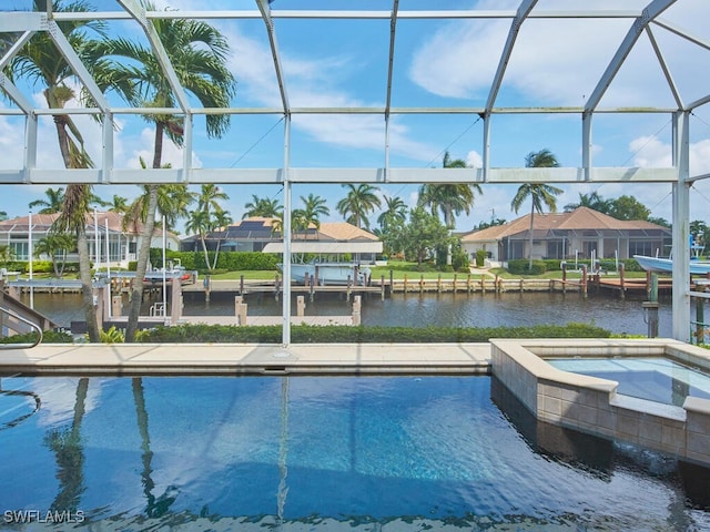 view of pool with glass enclosure, an in ground hot tub, and a water view