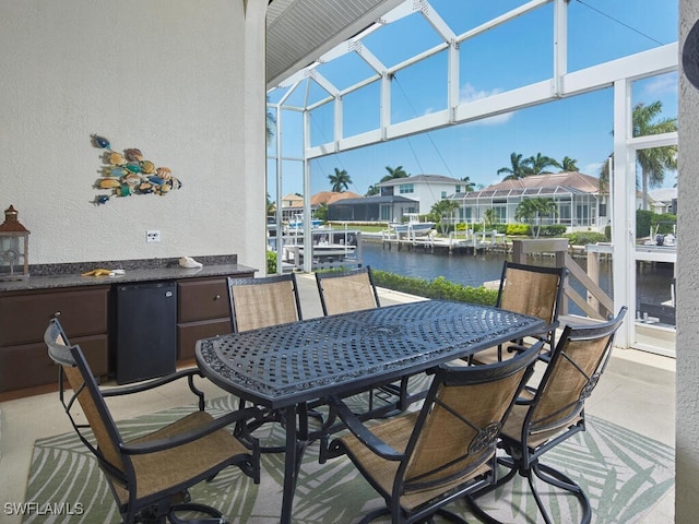 exterior space featuring glass enclosure, a water view, and a boat dock