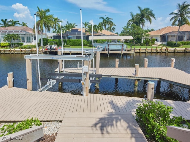 view of dock featuring a water view, boat lift, and a residential view