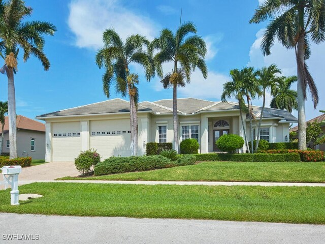 single story home featuring a front lawn and a garage