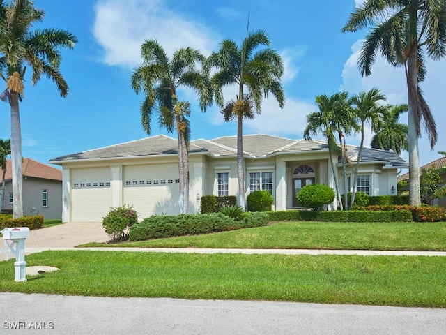 ranch-style home featuring driveway, stucco siding, a garage, and a front yard