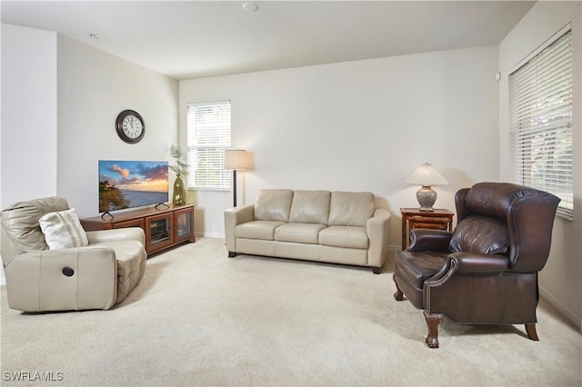 living room with baseboards, a wealth of natural light, and light colored carpet