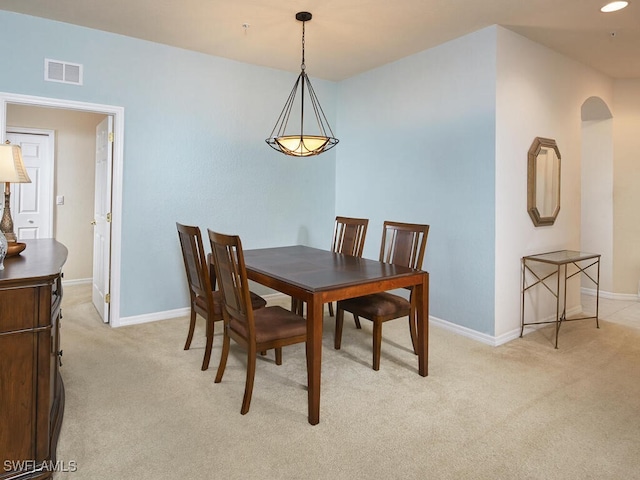 dining space featuring arched walkways, recessed lighting, light colored carpet, visible vents, and baseboards