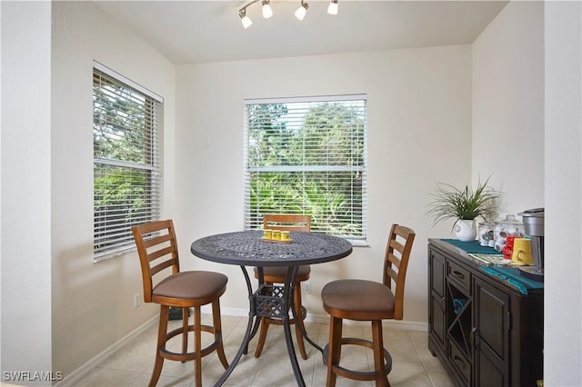 dining room featuring track lighting, baseboards, and light tile patterned floors