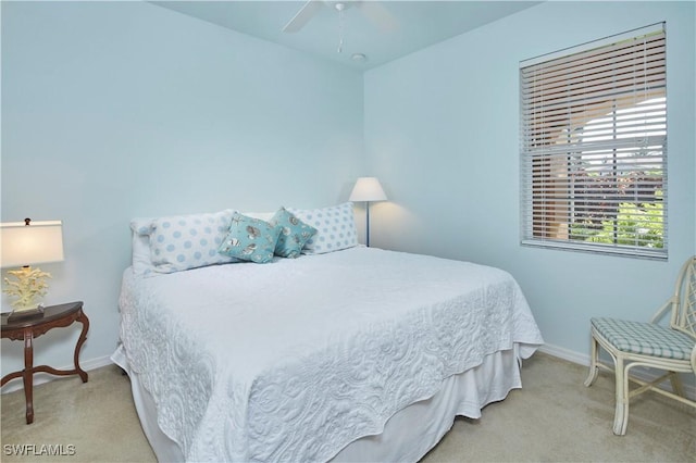 bedroom featuring light carpet, a ceiling fan, and baseboards